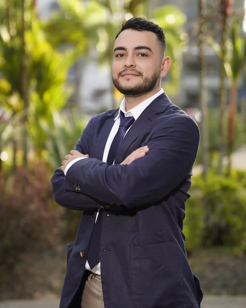 Alejandro Jiménez, gerente general de KAJC TECH SOLUTIONS, de traje azul con los brazos cruzados